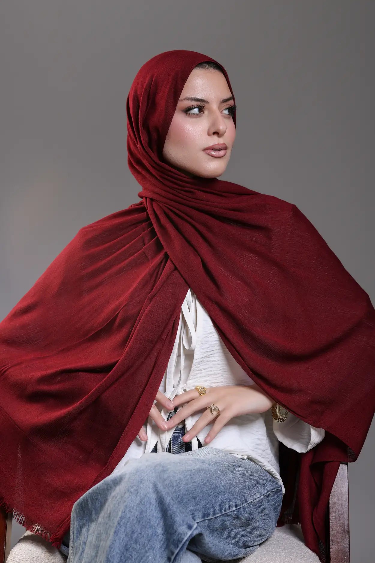 Woman wearing a red hijab with a gray background